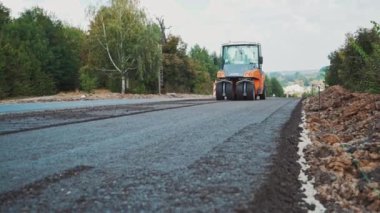 Yol yapımı ekipman makineleri. Asfalt paten kırsalda yeni bir yol açıyor