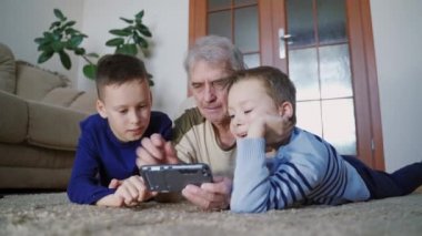 Son sınıflar ve çocuklar cep telefonu tutuyorlar. Mobil, iletişim ve teknoloji kavramını işaret eden çocuklu özenli büyükbaba
