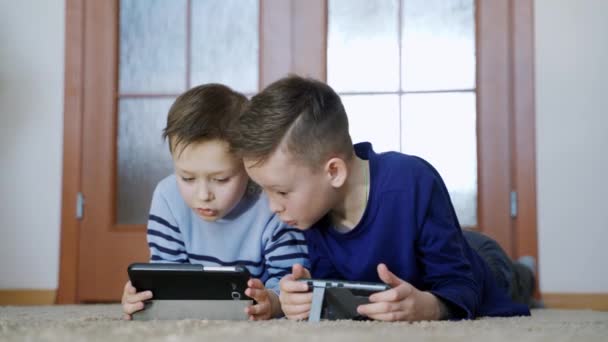 两个带着小玩意的孩子兄弟们在家里用智能手机玩网络游戏 现代通信和电子产品成瘾的概念 — 图库视频影像