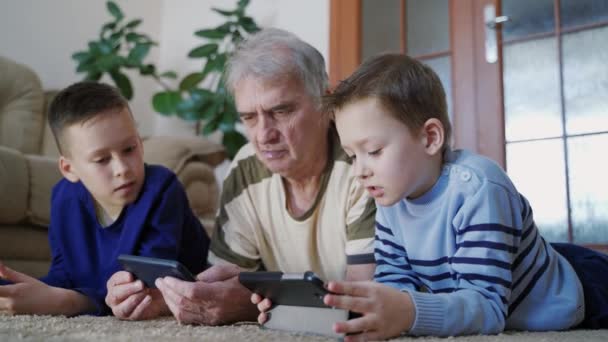 Família Usando Tecnologias Casa Velho Feliz Seus Netos Relaxando Chão — Vídeo de Stock