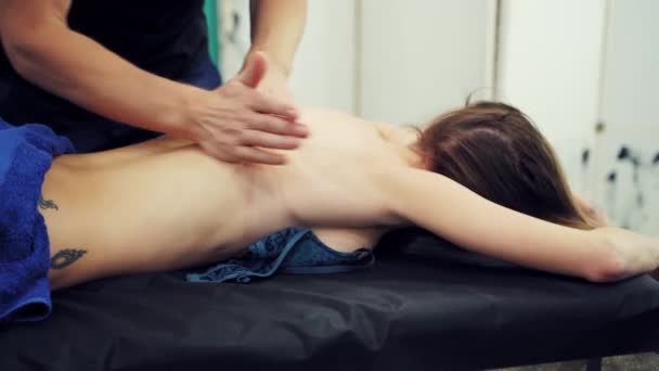 治疗师正在做治疗性的治疗性按摩 按摩师在温泉沙龙按摩床上为病人按摩的部分图像 — 图库视频影像