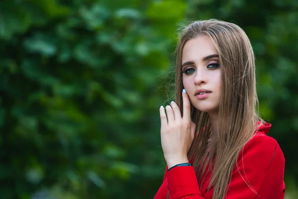 緑の木の背景に赤いドレスを着て魅力的な女性の写真 長い髪だ 美しい少女の肖像画 若い女性の写真セッション — ストック写真