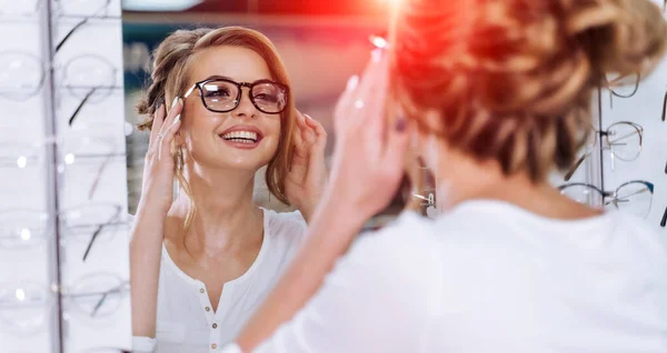 Young girl buys glasses. Optics. Emotions. Optical store