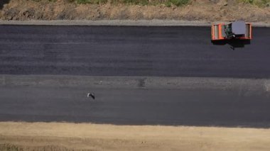 Yol paten makinesi asfalt yuvarlar. Yeni yol inşaatında çalışan yol silindirlerinin hava manzarası