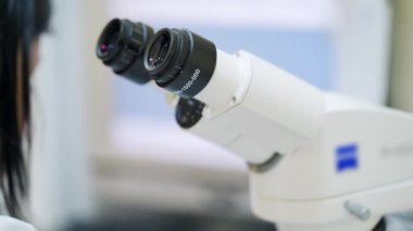 Laboratuvarda çalışan bir bilim adamı. Doktor kadın mikroskopla çalışıyor.