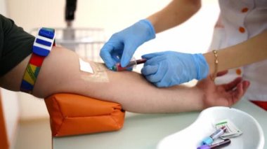 Kan koleksiyonu sırasında enjekte edilmiş. Doktor muayenehanesindeki hastadan kan örneği alan hemşire.