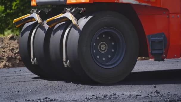 新鮮なアスファルト建設 新しい道路建設現場で働く道路ローラーの近くのビュー — ストック動画