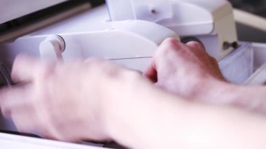 Gözlük tamir eden bir gözlükçü. Optisyen, optik mağazadaki en son dijital aygıt üzerinde gözlük ölçüyor ve hazırlıyor