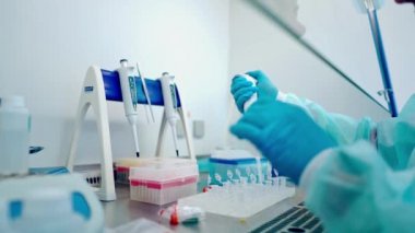 Laboratuvar çalışanı tarafından biyokimyasal analiz. Bilimsel tıp araştırmaları modern laboratuarda gözlük tüplerini test ediyor.