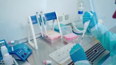 Yenilikçi İlaç Laboratuvarı 'nda bilim adamı. Deneme tüpleri üzerinde çalışırken eldiveni mikro boru ile kapat.