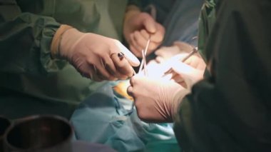 Bir grup cerrah ameliyathanede. Bir grup doktor ameliyat sırasında bir hastaya konsantre oluyor.