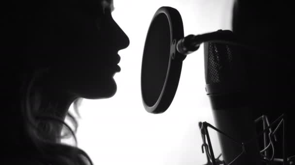 侧视图迷人的女性的脸完美的鼻子和美丽的嘴唇歌唱的麦克风 歌手站在麦克风前唱歌 黑人和白人 — 图库视频影像