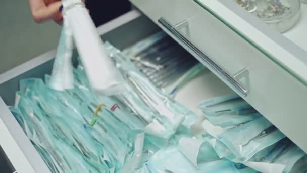 在诊所取出消毒牙科工具的详情 戴乳胶手套的手从抽屉里取出仪器 牙医的概念 后续行动 — 图库视频影像