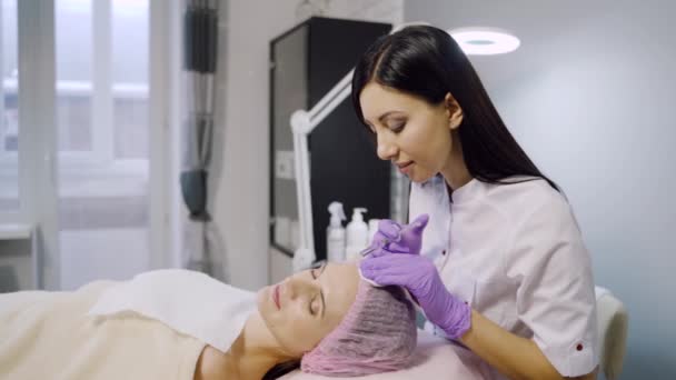 Young Beautiful Dark Haired Woman Gets Rejuvenating Facial Injections Work — Stock Video