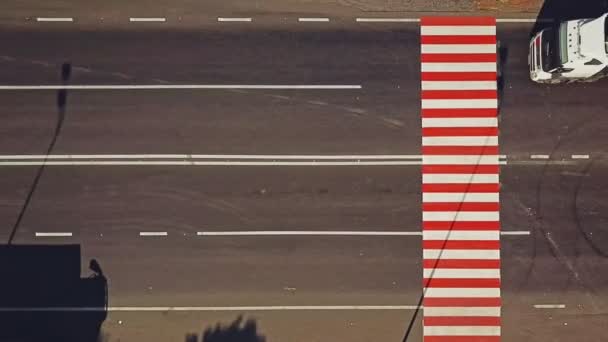 斑马交叉口漆成明亮的红色和白色 车上的车辆在移动 人行横道和一些红色的垂直线写在前面的道路上 空中风景 左动议 — 图库视频影像