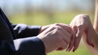Damat alyansı gelinin parmağına takar. Yeni evlendim. Gelin ve damat alyanslarını takıyorlar..
