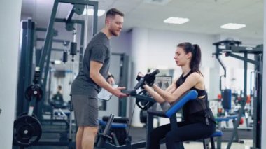 Spor salonunda egzersiz yapan güzel bir genç bayan. Pazılar için egzersizler. Kişisel eğitim.