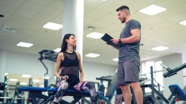 Spor salonunda müşterisiyle çalışan kişisel antrenör. Kişisel fitness eğitmeni.