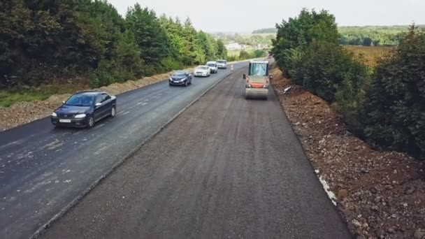 로울러 도로의 면에서 도로의 차들의 움직임의 배경에 아스팔트 건설을 공중에서 — 비디오
