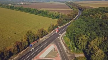 Çevresindeki harika tarlaların ve ağaçların arka planındaki bir yol parçasının onarımıyla birlikte uzun otoyolun manzarası. Hava manzarası