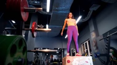 Formda atletik kadın spor salonunda boks yapıyor. Yoğun egzersiz günlük vücut geliştirme programının bir parçasıdır..