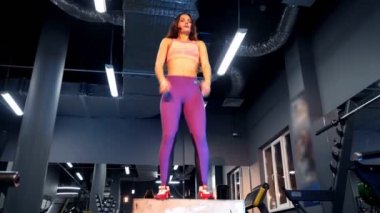 Spor salonunda tahta kutuya atlayan genç bir kadın. Crossfit jimnastik salonunda güzel kadın eğitimi