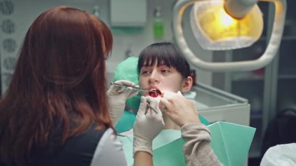 Dentist Examines Oral Cavity Young Client Who Sitting Dental Chair — Stock Video