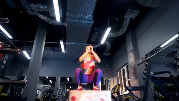 穿着运动服的迷人的健身女人在培训中心的一个大盒子上跳着 年轻强壮的女性 身材完美 在体育馆里跳起一套包厢 交叉适应训练 — 图库视频影像