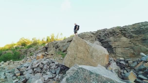 Turista Piedi Una Grande Roccia Alza Mani Sullo Sfondo Pietre — Video Stock