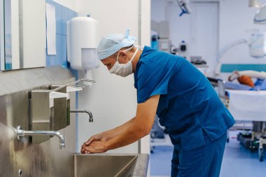 Doktor elleri dezenfekte eder. Tıp uzmanı ellerini yıkar. Ameliyat..