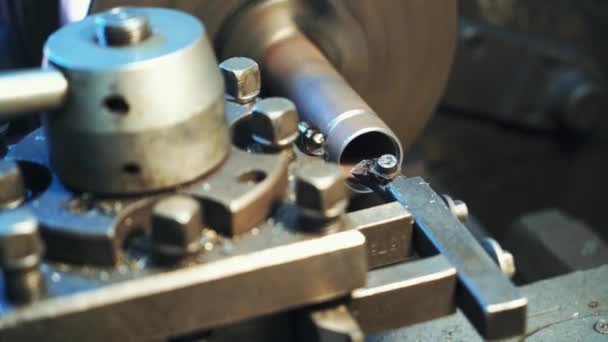Une pièce métallique tourne et affûte sur le tour dans l'atelier de fabrication. Gros plan .