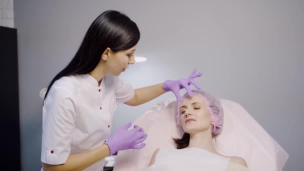 Belo Cosmetologista Aconselha Cliente Que Deita Uma Cadeira Examina Suas — Vídeo de Stock