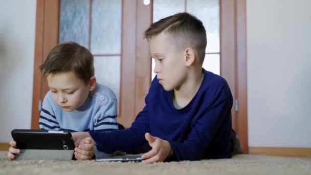 Söta Pojkar Ligger Golvet Vardagsrummet Och Spelar Moderna Enheter Med — Stockvideo