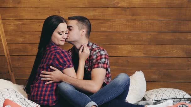 ロマンチックなカップルのシャツとジーンズはベッドの中で一緒に座っており 屋内でお互いを愛しています 情熱的なカップルに落ちる小さな赤い心 スローモーション — ストック動画