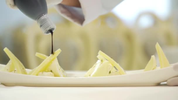 一位厨师在三块硬奶酪中加入了美味的酱汁 在餐馆里为客人准备的节日餐桌旁的一个白色盘子里放着Feta 后续行动 — 图库视频影像