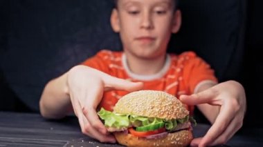 Genç mutlu genç lezzetli hamburger yiyor. Lezzetli ızgara burger.