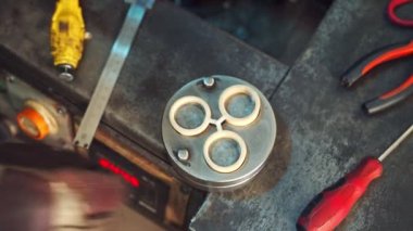 Kalın siyah eldivenli indüriyal işçi metal aletleri küçük parçalara ayırıyor. Metal endüstrisi. Kapalı alanda çalışma süreci. Yakın plan.