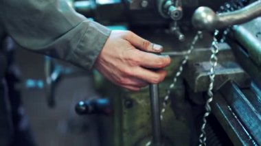 Makine operatörü endüstriyel bir makineyi çalıştırıyor. Torna ve metal fabrikalarında çalışan bir adam endüstriyel fabrikada üretim salonunda çalışıyor.