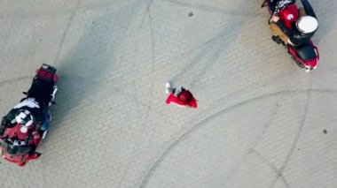 Etrafında dolaşan iki profesyonel motosikletlinin ortasında duran kızıl saçlı kadın. Yoldaki genç ve güzel bir kadın ve motosikletlinin manzarası..