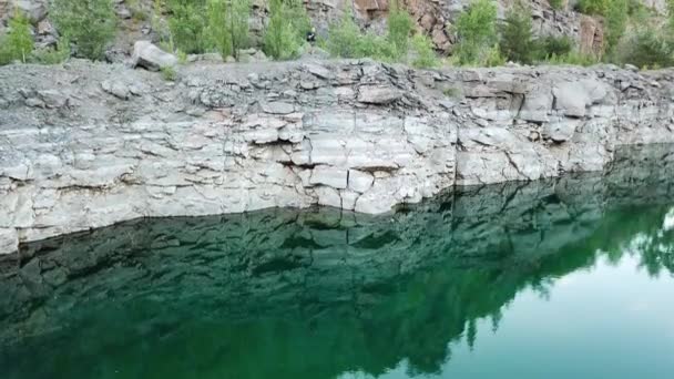 落基悬崖映衬在绿水中 游客穿着夏装凝视着它 山上的自然景观是室外的 相机移动底部顶部 — 图库视频影像