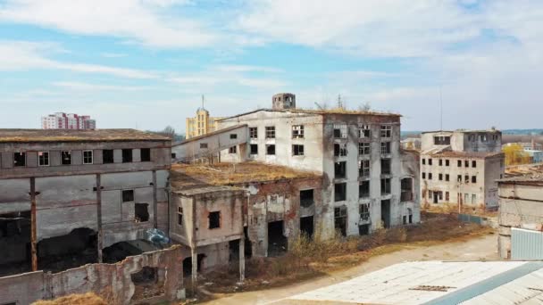 放棄された建物の空中ビューは 軍事行動の後に破壊された 壊れた窓や大きな穴を持つ産業建築を破壊した カメラが前に進む — ストック動画
