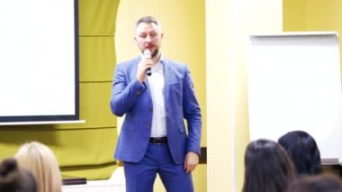 İdari lider mikrofonla konuşuyor ve halka açık seminerde el kol hareketi yapıyor. Konferans sırasında profesyonel konuşmacı.