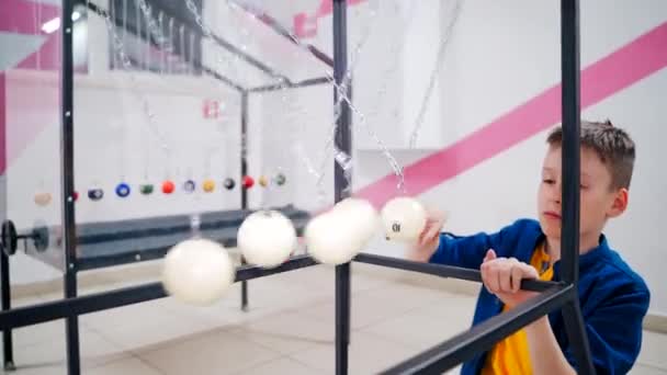 男孩用牛顿的钟摆做实验 物理学的概念 科学博物馆 — 图库视频影像