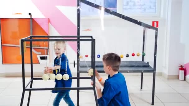 ニュートンのクレードルを実験する科学センターの子供たち 物理学の概念 科学博物館 — ストック動画