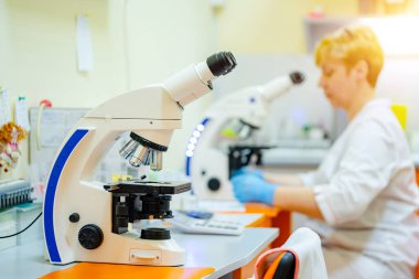 Laboratuvar asistanları kan örneğini inceliyor. Eldivenlerde yardım. Önlem olarak. Zatürree teşhisi. COVID-19 ve koronavirüs teşhisi. Salgın.