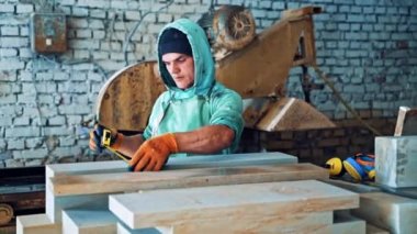 Fabrikada rulet masası olan bir işçi. Ciddi bir adam endüstriyel fabrikanın arka planında mezurayla çalışıyor..