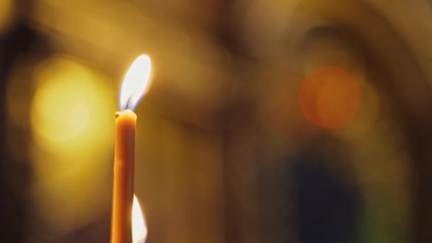 教堂里一支蜡烛闪烁着光芒 金色的烛焰 点燃蜡烛是灵性的象征 后续行动 — 图库视频影像