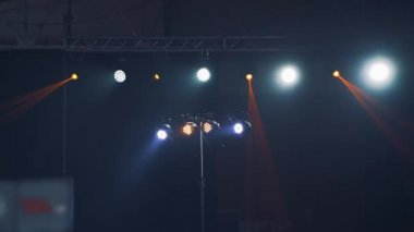 Gece kulübünde projektörlerin parlak renkleri sahne ışıklarını değiştiriyor. Müzik konseri sırasında ışıklar yanıp sönüyor..