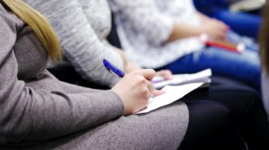 Konferansta kadınların ellerinin kalem tutarken ve not alırken yakın plan çekimleri. Kadın kongre toplantısında kalemle yazıyor..