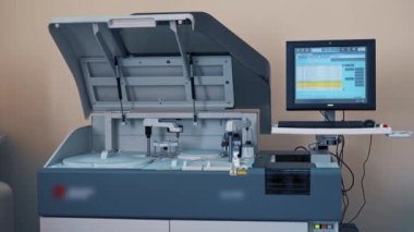 İşyerinde otomatik makine ve laboratuvar odasındaki bilgisayar ekranı. Hastane laboratuvarında kan tahlili. Robot makinede 3 boyutlu görüntülü kan örnekleri..